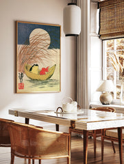 Japanese style art print of a frog and goldfish in a crescent moon boat with tall grass and a full, in a styled room mockup