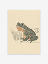 Humorous frog art print showing a frog sitting on a toilet reading a newspaper, in black, orange, and beige tones.