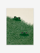 Illustrated frog art print with two green frogs peeking from tall green grass against a cream background.