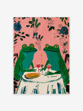 Two whimsical green frogs on a date at a table with wine and candle, pink background with leaves