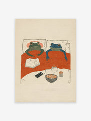 Whimsical frog wall art illustration of two frogs in bed with popcorn, a book, and headphones for a cozy night in.