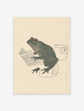 Humorous Frog Wall Art illustration of a dark green frog with red eyes sitting on a toilet, reading a newspaper, on a light background.