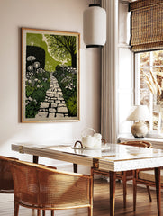 Illustrative garden path print with winding stone path, green foliage, and white flowers, in a styled room mockup
