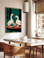 Illustrative wall art of two white geese with red beaks at a table with coffee cups and cake, in a styled room mockup