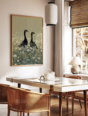 Two black geese with gold head markings standing in a field of white wildflowers on a beige, in a styled room mockup