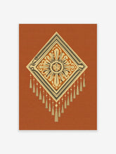 Geometric diamond wall art with orange and cream ornate pattern, tassels, and concentric borders on terracotta background
