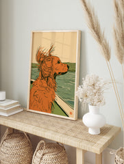 Illustration of a ginger dog looking out from a boat over calm water with green hills in the, in an alternate framed mockup