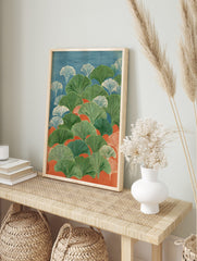 Illustrative ginkgo leaves in green and white against blue and orange background, in portrait, in an alternate framed mockup