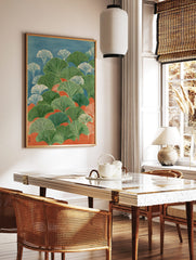 Illustrative ginkgo leaves in green and white against blue and orange background, in portrait, in a styled room mockup