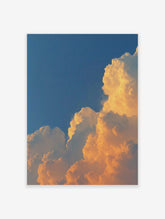 Dramatic golden cumulus clouds against a deep blue sky, capturing a vibrant sunset or sunrise