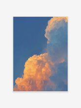 Dramatic golden orange sunset clouds against a clear blue sky, filling the frame with natural light