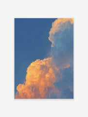 Dramatic golden orange sunset clouds against a clear blue sky, filling the frame with natural light