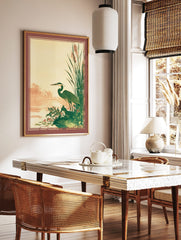 Illustrative great blue heron and fox by a pond with reeds, in green, brown, and beige tones, in a styled room mockup