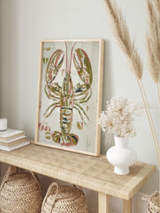 Illustrative lobster art print in olive green, reddish-pink, and white on a textured, in an alternate framed mockup