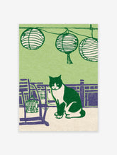 Illustrative green cat print featuring a black and white tuxedo cat sitting among purple furniture and Japanese lanterns.