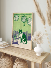 Illustrative green cat print featuring a black and white tuxedo cat sitting among purple furniture and Japanese lanterns. - Image 3
