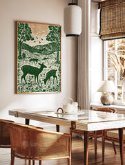 Illustrative green deer family in forest with trees and hills, woodcut style nature print, in a styled room mockup