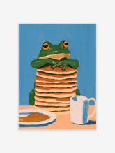 Whimsical illustration of a green frog with orange eyes leaning on a tall stack of pancakes with a white mug
