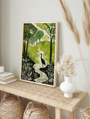 Green and white woodcut print of a heron in a winding river, surrounded by forest trees and, in an alternate framed mockup
