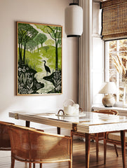 Green and white woodcut print of a heron in a winding river, surrounded by forest trees and, in a styled room mockup