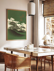 Illustrative Japanese art print with dark green mountains, cream waves, clouds, and gold kanji, in a styled room mockup