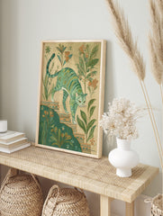Illustrative green striped cat walking down ornate steps amidst botanical plants and peach, in an alternate framed mockup