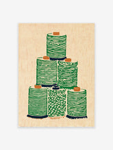Green thread spool wall art illustration stacked on a light beige background with an illustrative, textured style.