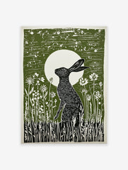 Green linocut print of a black hare sitting in wildflowers under a full moon, capturing a serene nocturnal scene.