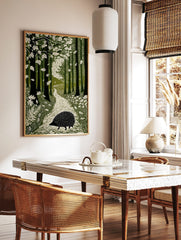 Linocut-style art print of a hedgehog on a winding path through a green forest with falling leaves, in a styled room mockup