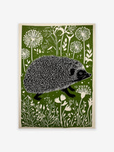 Linocut print of a hedgehog walking through a green and white stylized meadow with dandelion-like flowers.