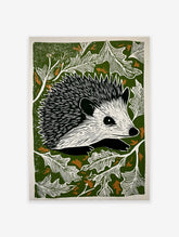 Hedgehog linocut print with black and white hedgehog surrounded by white leaves on a dark green background with brown accents.