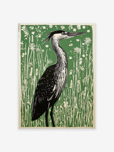 Linocut art print of a heron bird standing in tall green grass and white wildflowers.