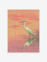 Japanese style heron wall art print featuring a white egret standing in pink and orange water with a sunset sky.