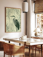 Illustrative dark green heron in profile against vertical cream reeds wall art print, in a styled room mockup