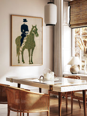 Textured dark green horse and black rider silhouette art print on a light beige background, in a styled room mockup