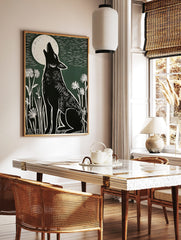 Black howling wolf linocut art print under a white full moon with white wildflowers on a green, in a styled room mockup