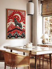 Illustrative red, black, and off-white art print of a howling wolf on a mountain under a crescent, in a styled room mockup