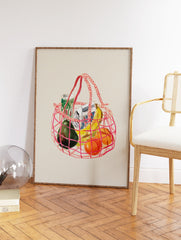 Illustrated art print of a pink net grocery bag filled with avocado, bananas, oranges, and a carton on a beige background. - Image 2