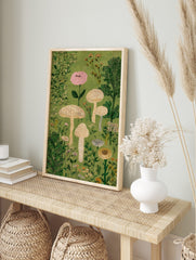 Illustrative mushroom and botanical wall art print with pink flower, beige mushrooms, and, in an alternate framed mockup