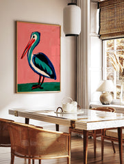 Illustrative painting of a pelican with a red beak, teal and blue body on a pink background, in a styled room mockup