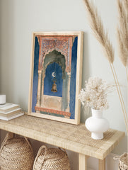 Ornate Indian architectural archway with a hanging brass bell and crescent moon against a, in an alternate framed mockup
