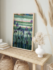 Purple iris flowers with green stems against a textured, multi-coloured striped background in, in an alternate framed mockup