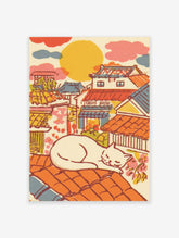 Illustrative Japanese Cat Art print of a white cat sleeping on an orange tiled roof overlooking a colorful traditional townscape.