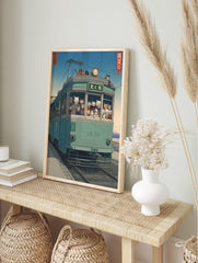Japanese Ukiyo-e style art print of cats riding a teal tram with a distant mountain and blue, in an alternate framed mockup