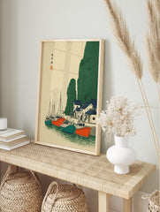 Japanese coastal village wall art with fishing boats, green cliffs, and blue-roofed houses in, in an alternate framed mockup