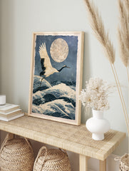 Japanese crane in flight over stylized ocean waves and a large textured moon in an, in an alternate framed mockup