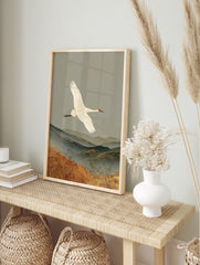 White crane flying over layered mountains and golden grasses, traditional Japanese style, in an alternate framed mockup