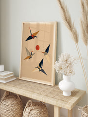 Stylised Japanese crane birds in flight around a red sun on a textured beige background, in an alternate framed mockup