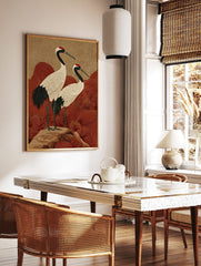Japanese crane wall art with two red-crowned cranes on a rock, with red wave patterns and a, in a styled room mockup