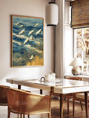 Japanese Red-crowned cranes flying over blue ocean waves with gold outlines and golden reeds, in a styled room mockup